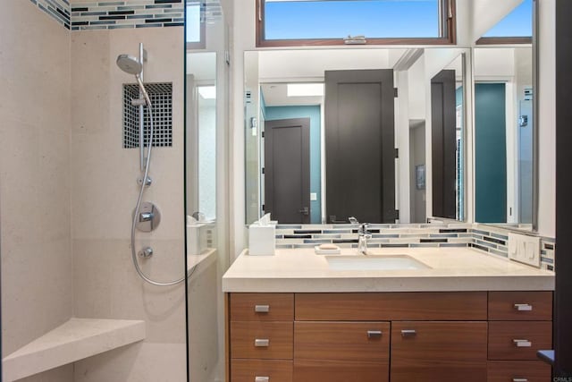 bathroom with decorative backsplash, vanity, and tiled shower