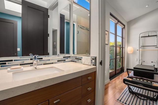 bathroom with hardwood / wood-style floors, vanity, and tasteful backsplash