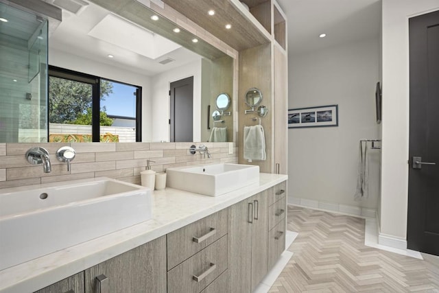 bathroom featuring a skylight, parquet floors, backsplash, vanity, and a shower with shower door