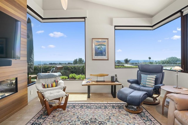 living area featuring a fireplace, light tile patterned floors, and lofted ceiling