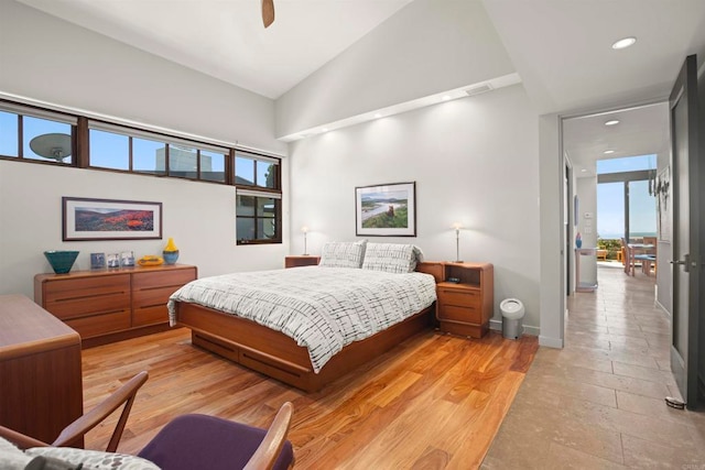 bedroom with high vaulted ceiling, light hardwood / wood-style flooring, multiple windows, and ceiling fan