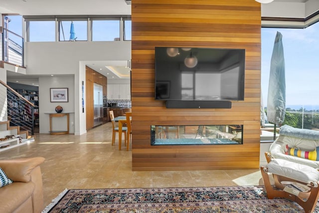 living room featuring a multi sided fireplace and a high ceiling