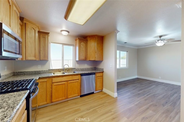 kitchen featuring ceiling fan, sink, crown molding, light hardwood / wood-style flooring, and appliances with stainless steel finishes