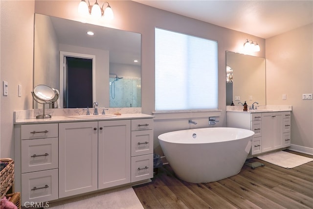 bathroom featuring vanity, separate shower and tub, and hardwood / wood-style flooring