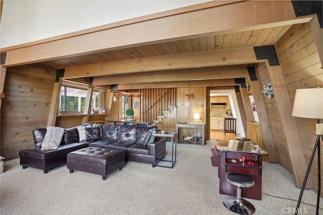 carpeted living room featuring beam ceiling, wooden walls, and wood ceiling