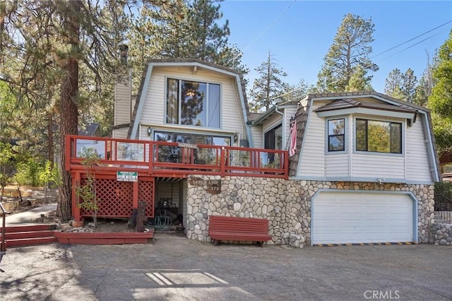 rear view of property with a garage and a deck