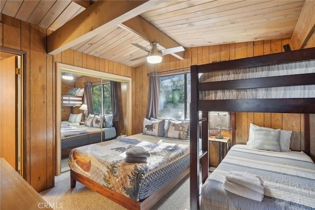 carpeted bedroom with ceiling fan, wooden ceiling, and wooden walls