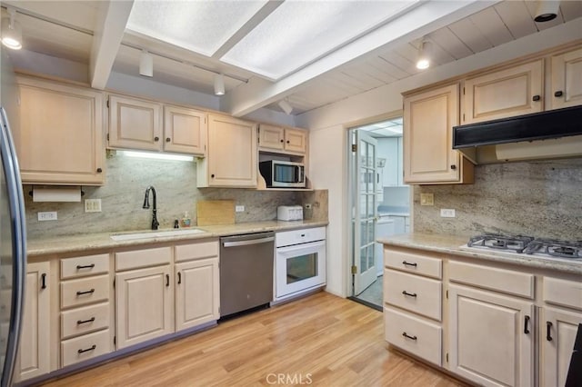 kitchen with backsplash, stainless steel appliances, light hardwood / wood-style floors, and sink