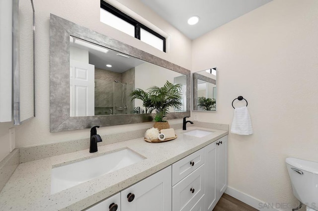 bathroom featuring walk in shower, vanity, and toilet