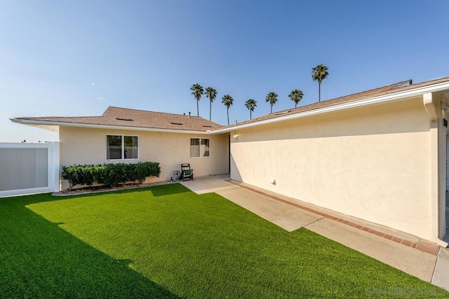 rear view of property with a patio area and a yard