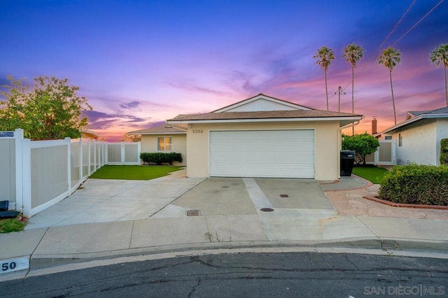 ranch-style home featuring a garage and a lawn