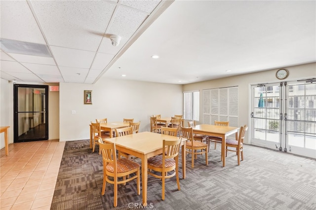 tiled dining room with a drop ceiling