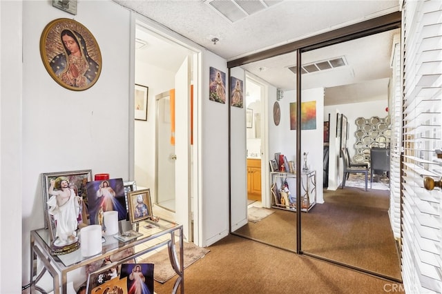 hallway featuring a textured ceiling and carpet