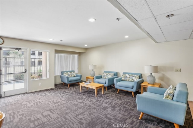 carpeted living room with a paneled ceiling