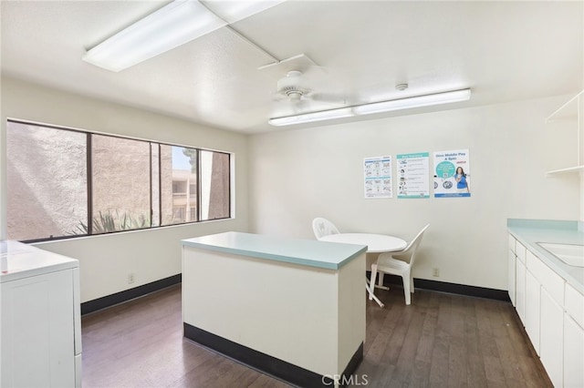 office with washer / clothes dryer, sink, and dark hardwood / wood-style flooring