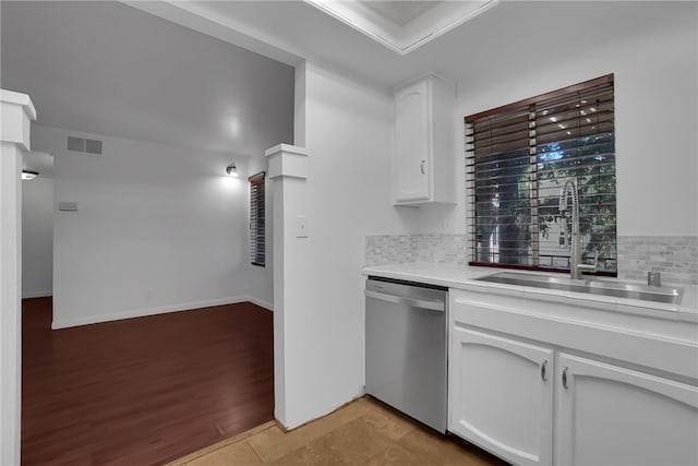 kitchen with dishwasher, sink, tasteful backsplash, light hardwood / wood-style floors, and white cabinetry