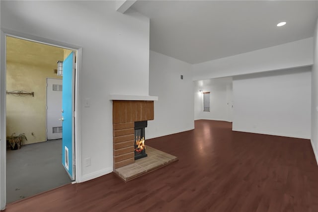 unfurnished living room with a fireplace and dark wood-type flooring