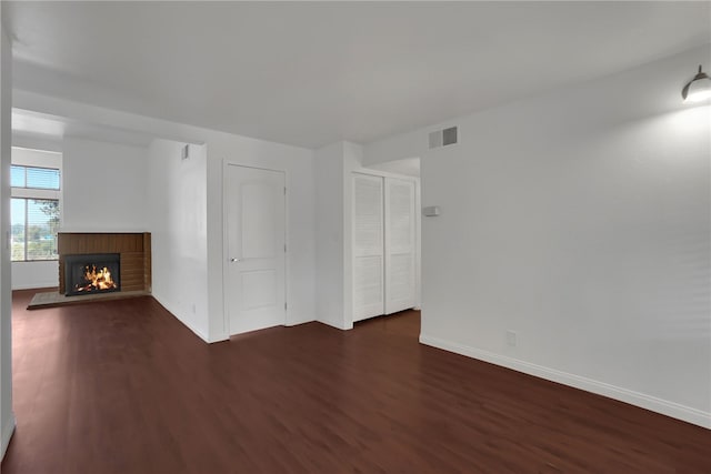 unfurnished living room with dark hardwood / wood-style flooring and a fireplace