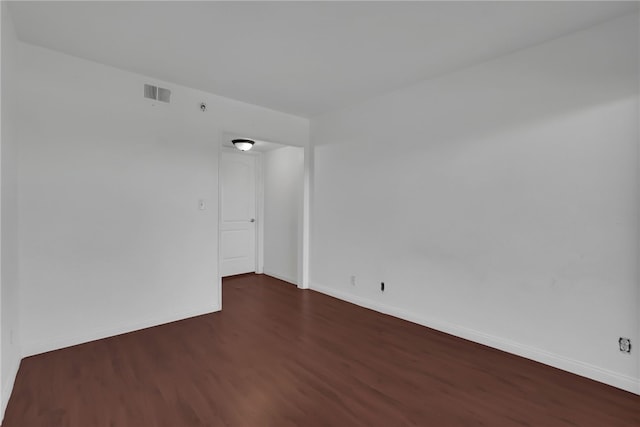 spare room featuring dark wood-type flooring