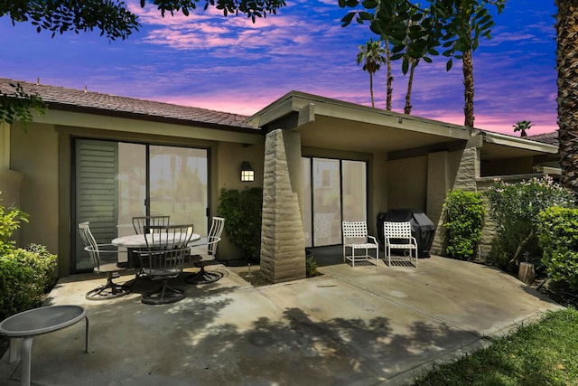 back house at dusk with a patio