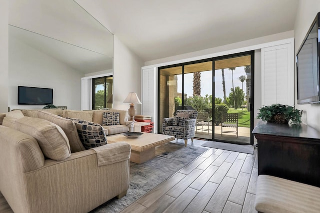 living room featuring vaulted ceiling and hardwood / wood-style floors