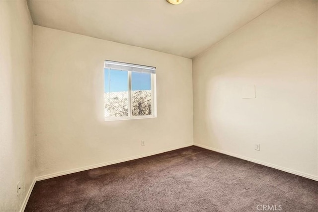 spare room featuring carpet and lofted ceiling