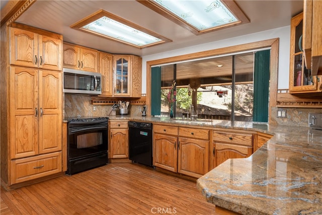 7226 Yosemite Park Way, Yosemite, CA 95389 - kitchen featuring light stone counters, sink, light hardwood / wood-style flooring, backsplash, and black appliances