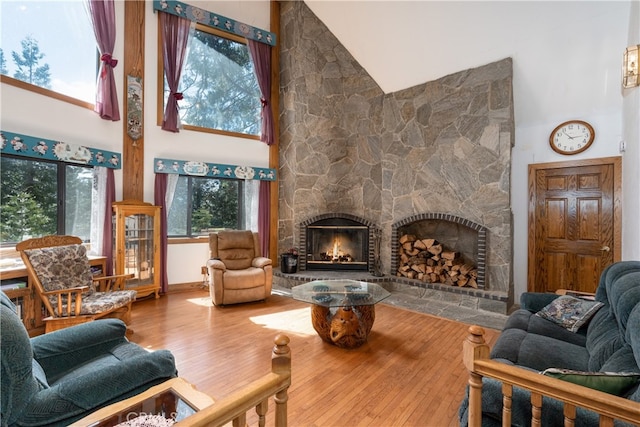 7226 Yosemite Park Way, Yosemite, CA 95389 - living room featuring high vaulted ceiling, hardwood / wood-style flooring, and a stone fireplace