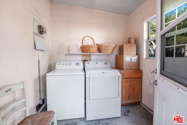 laundry area featuring separate washer and dryer and cabinets