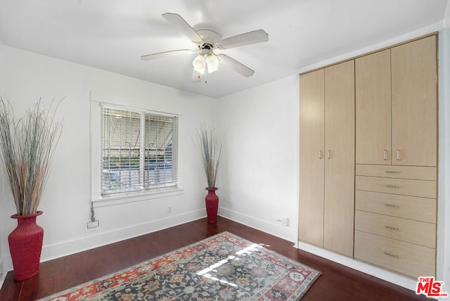 bedroom featuring ceiling fan, a closet, and dark wood-type flooring