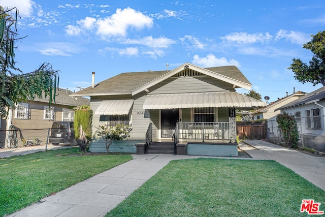 bungalow-style home featuring covered porch and a front yard