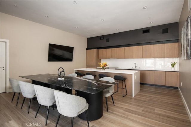 dining area with light hardwood / wood-style floors and sink