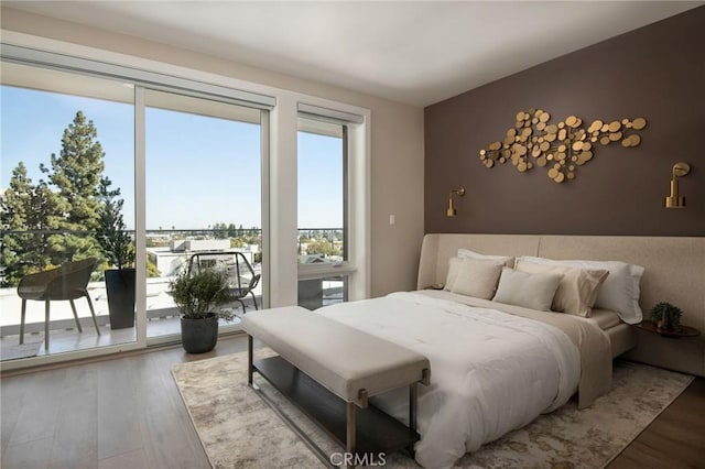 bedroom featuring wood-type flooring and access to outside