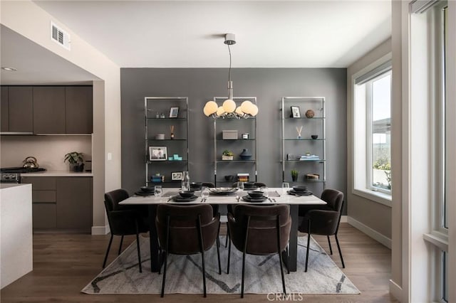 dining space with plenty of natural light, a notable chandelier, and hardwood / wood-style flooring