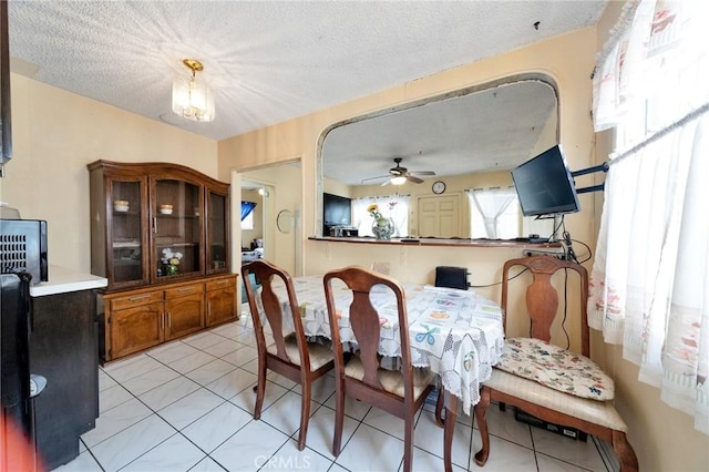 tiled dining room featuring a textured ceiling and ceiling fan