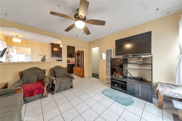 tiled living room featuring ceiling fan and a textured ceiling