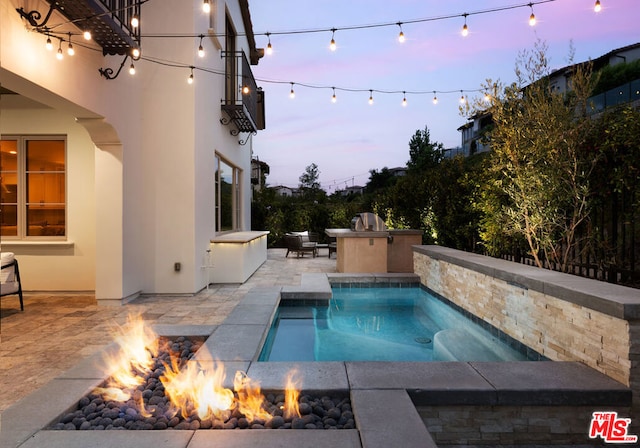 pool at dusk featuring a fire pit, a jacuzzi, and a patio