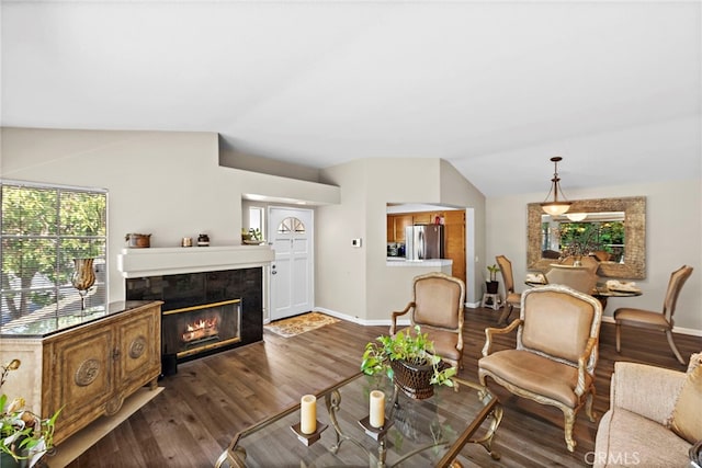 living room with dark hardwood / wood-style floors, a tile fireplace, and vaulted ceiling