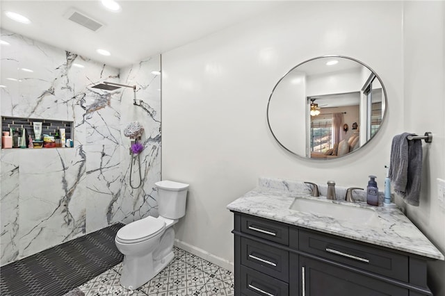 bathroom featuring a tile shower, vanity, toilet, and ceiling fan