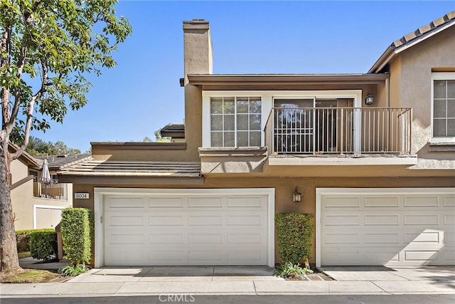 view of front facade featuring a balcony and a garage