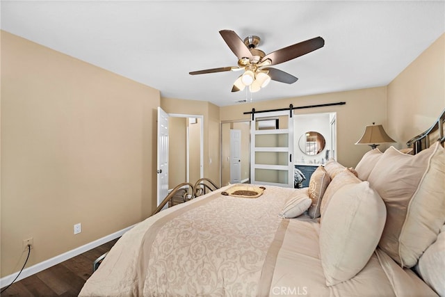 bedroom featuring hardwood / wood-style floors, a barn door, and ceiling fan