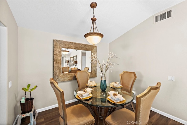 dining room with vaulted ceiling and dark hardwood / wood-style floors