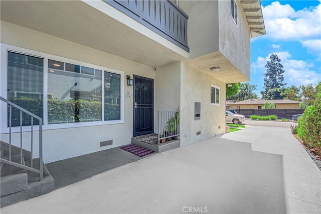 entrance to property with a balcony and a patio area