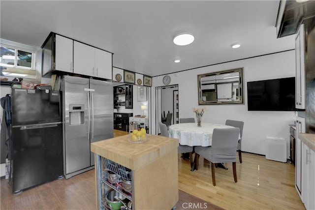 kitchen with white cabinets, high end refrigerator, black fridge, and light wood-type flooring