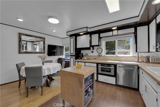4140 Baldwin Ave Unit A, Culver City, CA 90232 - kitchen with dishwasher, butcher block countertops, wall oven, wood finished floors, and white cabinets