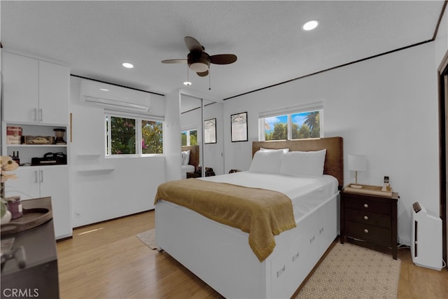 bedroom with ceiling fan, light wood-type flooring, and multiple windows