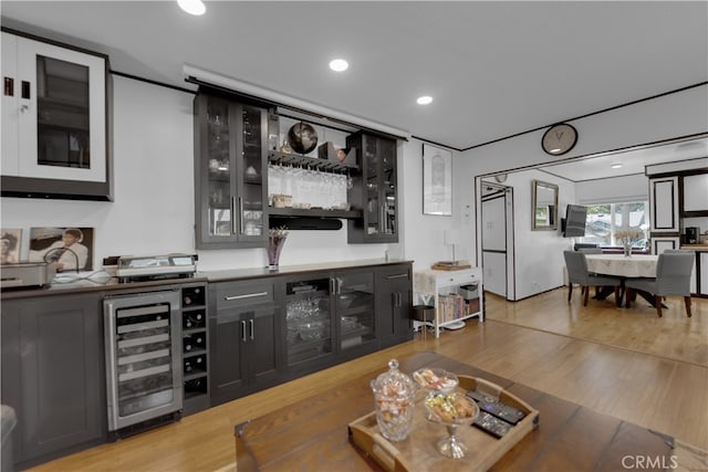 interior space featuring light wood-type flooring, bar area, and wine cooler