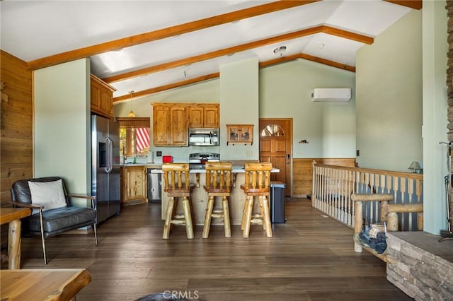 kitchen with appliances with stainless steel finishes, dark hardwood / wood-style flooring, a kitchen breakfast bar, a wall unit AC, and lofted ceiling with beams