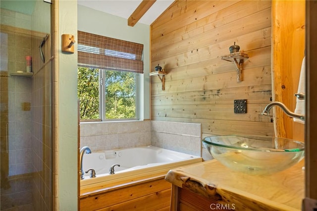 bathroom with a bathing tub, vanity, vaulted ceiling, and wooden walls