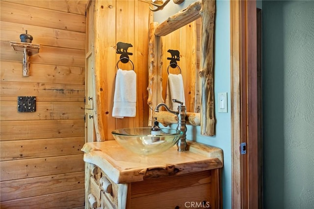 bathroom featuring wood walls and vanity